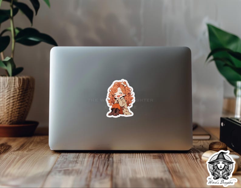 Puede incluir: Una pegatina con una ilustraci&oacute;n de dibujos animados de una joven con el pelo largo y rizado de color naranja que lleva un abrigo marr&oacute;n y botas. Est&aacute; sonriendo y se lleva la mano a la mejilla. La pegatina est&aacute; en un port&aacute;til plateado.