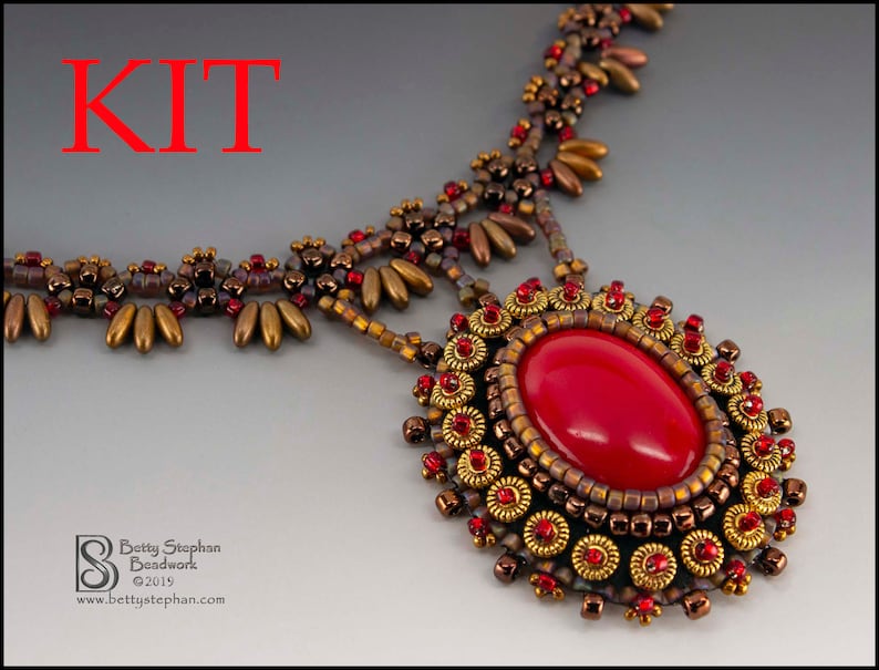 K&ouml;nnte beinhalten: Ein Perlenketten-Set mit einem roten Edelstein-Anh&auml;nger. Die Kette besteht aus goldenen und braunen Perlen in verschiedenen Gr&ouml;&szlig;en.