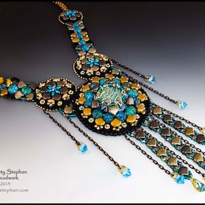 May include: A beaded necklace with a large, circular pendant featuring a blue and gold design. The necklace is made with black, gold, and blue beads and has a long, dangling chain with smaller beads.
