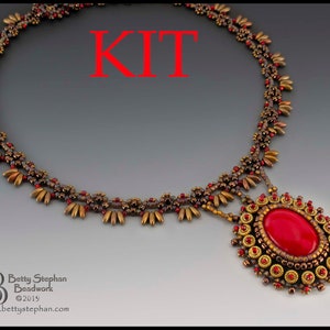 K&ouml;nnte beinhalten: Ein Perlenketten-Set mit einem roten Edelstein-Anh&auml;nger. Die Kette hat eine gold-braune Farbgebung mit einem sich wiederholenden Perlenmuster.