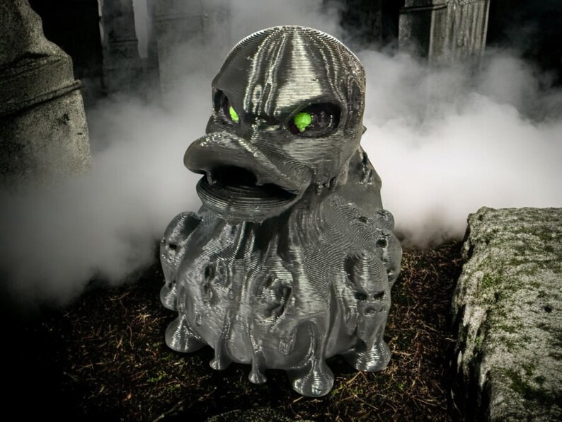 May include: A black rubber duck with green eyes, dripping with a melted, gooey texture. The duck is in a spooky setting with fog and stone structures.