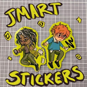 May include: Two stickers featuring cartoon illustrations of people, one with dark hair and the other with red hair, both wearing glasses. The stickers are on a gray surface with the words "SMART STICKERS" in yellow.