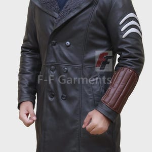 May include: A black leather coat featuring a shearling collar and brown sleeve accents. The coat has a double-breasted design and white stripes on the upper arm. The text "F-F Garments" is visible on the coat.