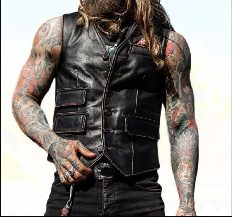 Peut inclure: Un gilet en cuir noir avec un devant &agrave; boutons et plusieurs poches. Le gilet a des d&eacute;tails de couture blanche autour des bords et des poches.