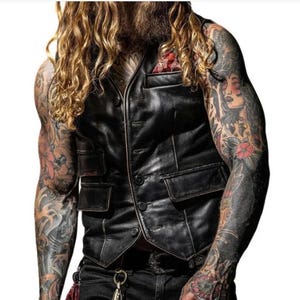 Peut inclure: Un gilet en cuir noir avec une fermeture &agrave; boutons et plusieurs poches. Le gilet a un aspect vieilli et est port&eacute; sur une chemise blanche.