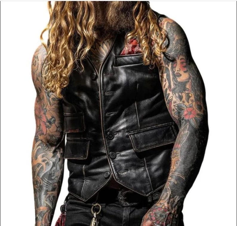 Peut inclure: Un gilet en cuir noir avec une fermeture &agrave; boutons et plusieurs poches. Le gilet a un aspect vieilli et est port&eacute; sur une chemise blanche.