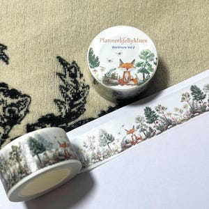 Op de afbeelding: Een rol washi tape met een bosmotief. De tape heeft een vos, bomen en paddenstoelen. De tape is gelabeld "PlannerlifeByMues Waldtiere Vol. 2".