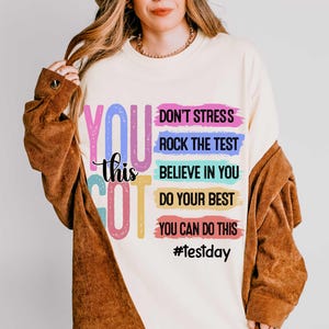 Puede incluir: Sudadera color crema con las palabras "YOU GOT this" en letras coloridas y divertidas. Texto adicional incluye "DON'T STRESS, ROCK THE TEST, BELIEVE IN YOU, DO YOUR BEST, YOU CAN DO THIS" y el hashtag "#testday".