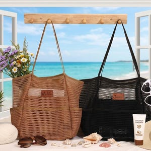 May include: Two mesh tote bags, one brown and one black, with long straps. The brown bag has a label that says "Holda", and the black bag has a label that says "Dinan". The bags are displayed with sunglasses, sunscreen, and a straw hat.