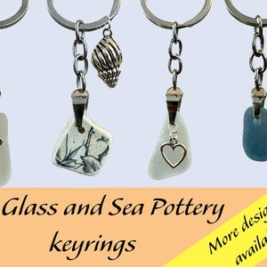 以下が含まれることがあります： 海のガラスと海の陶器を使ったキーホルダーが4つ。それぞれのキーホルダーには、銀色のリングと銀色のチャームが付いています。チャームには、貝殻、ハート、小さなバケツ、ハートがあります。海のガラスと陶器のピースは、白、青、茶色など、さまざまな形と色をしています。