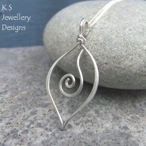 May include: A silver pendant necklace with a leaf-shaped design. The pendant features a spiral detail and is suspended from a delicate chain. The text "K S Jewellery Designs" is visible in the upper left corner.
