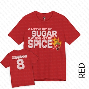 Puede incluir: Camiseta roja con el texto "A little bit of sugar a whole lot of spice" y un chile rojo con llamas. La parte posterior de la camiseta tiene el texto "Cunningham 8" en blanco.