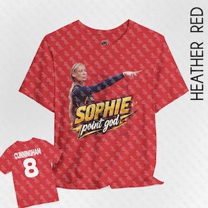 Puede incluir: Una camiseta roja jaspeada con un patrón repetitivo del texto Betty Lou. El frente muestra un gráfico de una jugadora de baloncesto con el texto SOPHIE point god. La parte posterior muestra el nombre CUNNINGHAM y el número 8 en letras blancas.