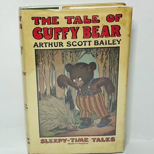 May include: Vintage children's book titled "The Tale of Cuffy Bear" by Arthur Scott Bailey. The cover features a brown bear in striped pants and a porcupine in a forest setting. The book is part of the "Sleepy-Time Tales" series.