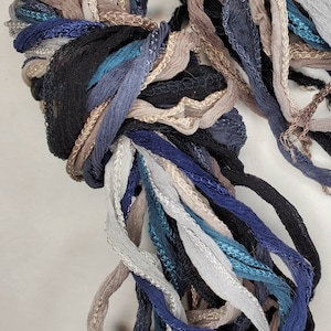 以下が含まれることがあります： 青、ターコイズ、グレー、ベージュの色合いのカラフルな刺繍糸の束。糸はシルク製で、どんなプロジェクトにもエレガントなタッチを加えるのに最適です。