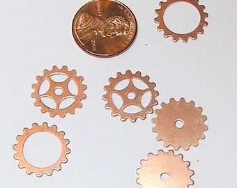 May include: Six copper gears of varying sizes and designs. The gears are on a white surface. The largest gear has a diameter of about 1 inch.