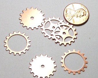 May include: Five copper gears of different sizes and designs. The gears are arranged in a semi-circle with a US penny in the center.