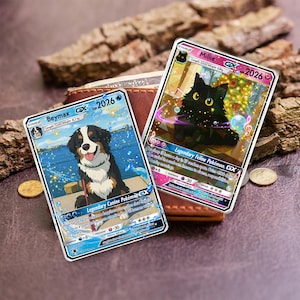 May include: Two collectible Pok&eacute;mon cards featuring a dog and a cat. The dog card is labeled "Beymax GX 2026" and the cat card is labeled "Millie GX 2026". The cards are on a brown surface with a wallet and coins.