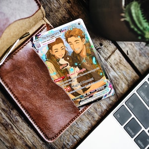 May include: A custom trading card featuring an illustrated couple and a dog, titled The Anniversary VMAX. The card includes text such as Power Couple, Magical Moment, and Everest Base Camp 08.24.2024, with a Mew icon and various game-style statistics.