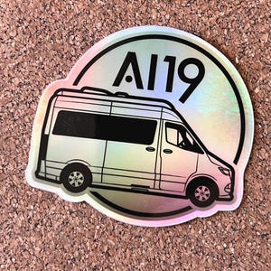 May include: A white van with a black outline and a black circle with the text "A119" in white. The circle has a holographic iridescent finish.