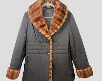 May include: A dark gray Esprit jacket with a brown faux fur collar and cuffs. The jacket has a quilted design on the front and fastens with two buttons. The jacket is hanging on a gray hanger.