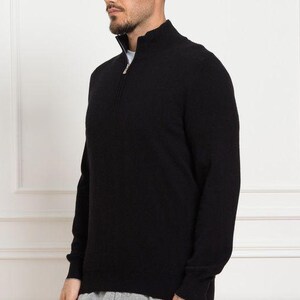 May include: A black mock neck sweater with a zipper.