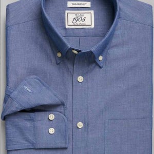 May include: A blue, long-sleeved button-down shirt with a white label that reads "F.A. Bush 1905 The New Tradition" and "Tailored Fit".