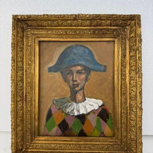 Puede incluir: Pintura al óleo de una persona con sombrero azul y camisa con estampado de arlequín, enmarcada en un marco dorado ornamentado. La pintura presenta un fondo neutro y un cuello blanco con volantes. La obra de arte es un retrato.