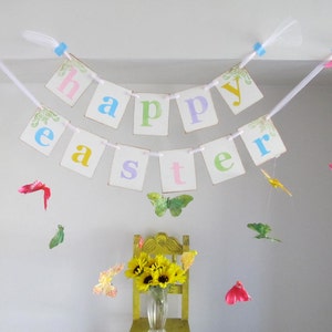 May include: A white banner with the words "Happy Easter" in colorful letters hangs from the ceiling.  Colorful paper butterflies are strung from the ceiling and hang around the banner.