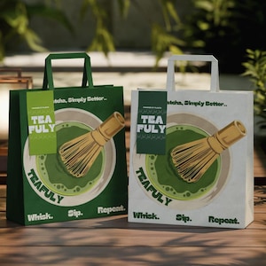 May include: Two paper shopping bags, one dark green and one white, each featuring a graphic of a bamboo matcha whisk in a bowl of green tea. The bags display the text "TEAFULY," "Matcha, Simply Better..," and "Whisk. Sip. Repeat." with a hanging tag.