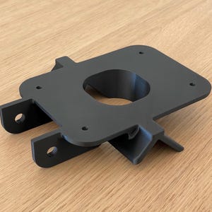 Könnte beinhalten: Ein schwarzer 3D-gedruckter Kunststoffhalter mit einem runden Loch in der Mitte und vier Befestigungslöchern am Umfang.