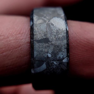 May include: A silver ring with a textured surface, made from meteorite material.