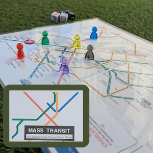 May include: A board game with a map of Boston's public transportation system, featuring colorful lines and station names. The game includes translucent player pieces in various colors and dice. The game's title, "MASS TRANSIT," is displayed on a card.