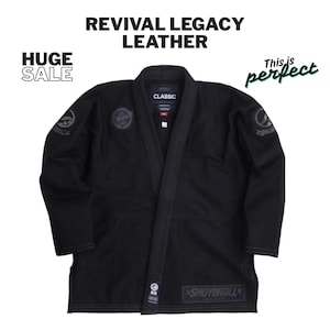 May include: Black martial arts gi with the text "REVIVAL LEGACY LEATHER" and "HUGE SALE". The gi has patches on the sleeves and chest, and the brand name "SHOYOROLL" is visible on the bottom. The gi is a classic design.