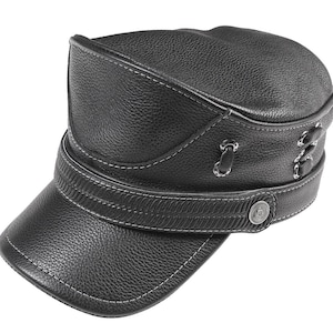 May include: Black leather cap with a short brim and a structured crown. The cap features white stitching along the seams and a decorative strap with a metal button. The design includes eyelets and a textured leather finish.