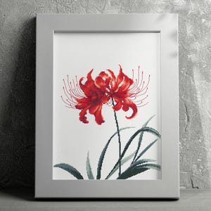 May include: A framed cross-stitch embroidery of a red spider lily with green leaves on a white background.