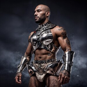 May include: A silver-colored metal chest and waist armor set with matching arm cuffs. The armor has a polished finish and is adorned with rivets and circular accents. The person wearing the armor has tattoos on their arms and chest.