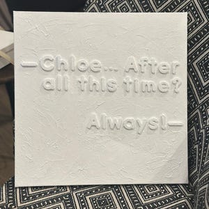 May include: Square white canvas with textured surface. The embossed text reads "-Chloe... After all this time? Always!-". The artwork is displayed against a patterned black and white background.