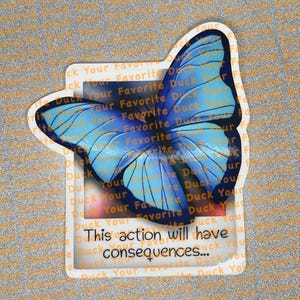 May include: A sticker featuring a blue butterfly with detailed wing patterns. The butterfly is set against a white frame with the text "This action will have consequences..." in black. The background has repeating text.