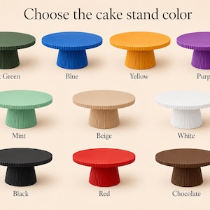 May include: Eleven round cake stands with a fluted pedestal base, displayed in a grid. The colors include dark green, blue, yellow, purple, mint, beige, white, black, red, and chocolate. The text at the top reads Choose the cake stand color.