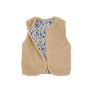 Könnte beinhalten: Eine beige Weste mit weichem, flauschigem Äußeren. Das Innenfutter zeigt ein Blumenmuster mit blauen, gelben und weißen Blumen auf weißem Grund. Die Weste hat einen Knopfverschluss.
