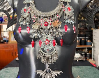 Set composto da bavaglino e orecchini "Ruby Bat Goddess Coffin": gioielli vistosi dipinti a mano con effetto anticato.