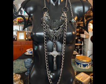 Set di collana e orecchini con crocifisso "Zanna Nera" di Marilyn Medusa, un pezzo unico della creazione.