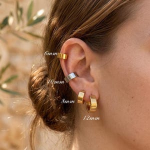 May include: A collection of four ear cuffs and hoop earrings in gold and silver tones. The set includes a 6mm gold cuff, a 10mm silver cuff, an 8mm gold hoop, and a 12mm gold hoop, each labelled with its respective metric size in millimetres.