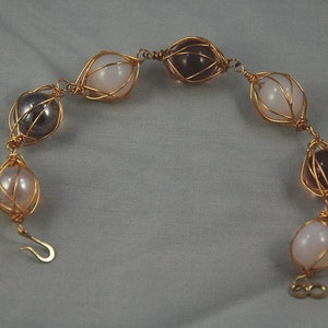 pink and red gold plated caged marble bracelet.