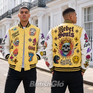 May include: A yellow and white varsity jacket featuring various graphic patches including skulls, a crown, a panther, dice, and the text Rebel Souls, Live Fast, Stay Wild, Chaos, and Lucky. The jacket has metal snap buttons and black striped trim.