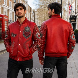 Peut inclure: Une veste universitaire en cuir rouge avec des boutons-pression argentés, un col et des poignets côtelés. La veste est ornée de broderies complexes incluant une couronne, un cœur, des papillons, des étoiles et des motifs floraux, avec des clous.