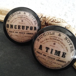 May include: Two black and white round labels with gold lettering. The labels are for Nichols & Noyes, publishers of "Birds of New England and Adjacent States". One label reads "Once Upon a Time" and the other reads "A Time". Both labels state "Public and Private Libraries, Books Imported, No. 117 Washington Street, Boston."