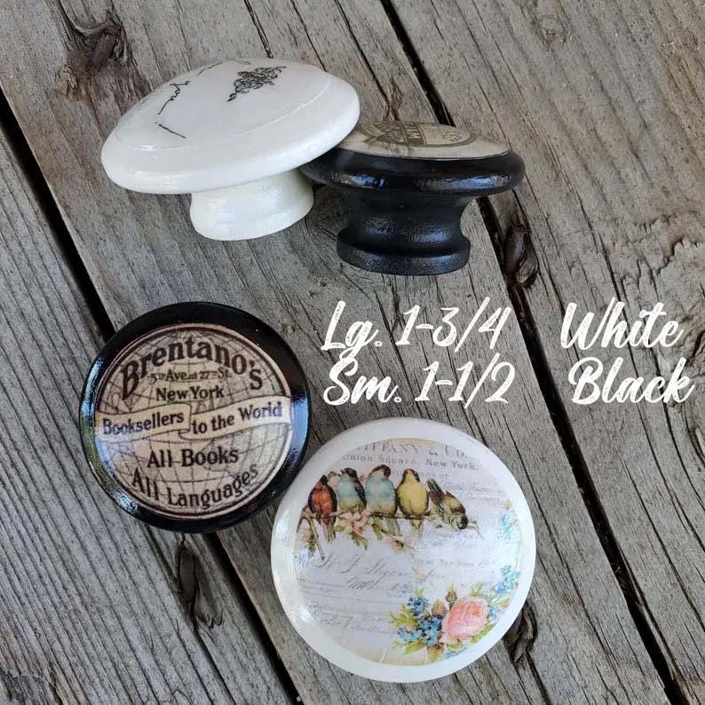 May include: Four decorative cabinet knobs in white and black. One knob has a black base with a white top. The other knobs have a white base with a black top. The knobs have various designs and text.