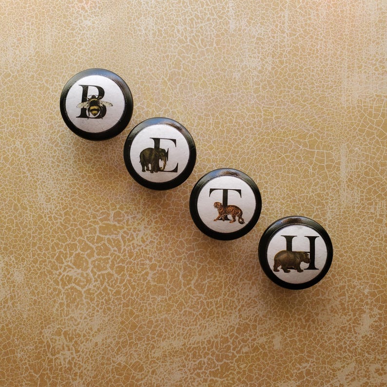 以下が含まれることがあります： 白のセラミックマグカップ、黒いハンドル、手書き風の「But First, Coffee」の文字。マグカップは白い表面に置かれています。マグカップの高さは10cmです。